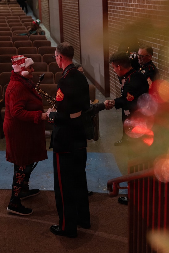 U.S. Marine Corps musicians with the Marine Forces Reserve Band greet community members at the conclusion of their performance at Morgan City Municipal Auditorium, Morgan City, Louisiana, Dec. 9, 2025. The Marine Forces Reserve Band performed for the local community to listen to holiday music in the areas surrounding New Orleans while supporting the collecting of new, unwrapped toys for Toys for Tots. (U.S. Marine Corps photo by Lance Cpl. Priscilla Flores)