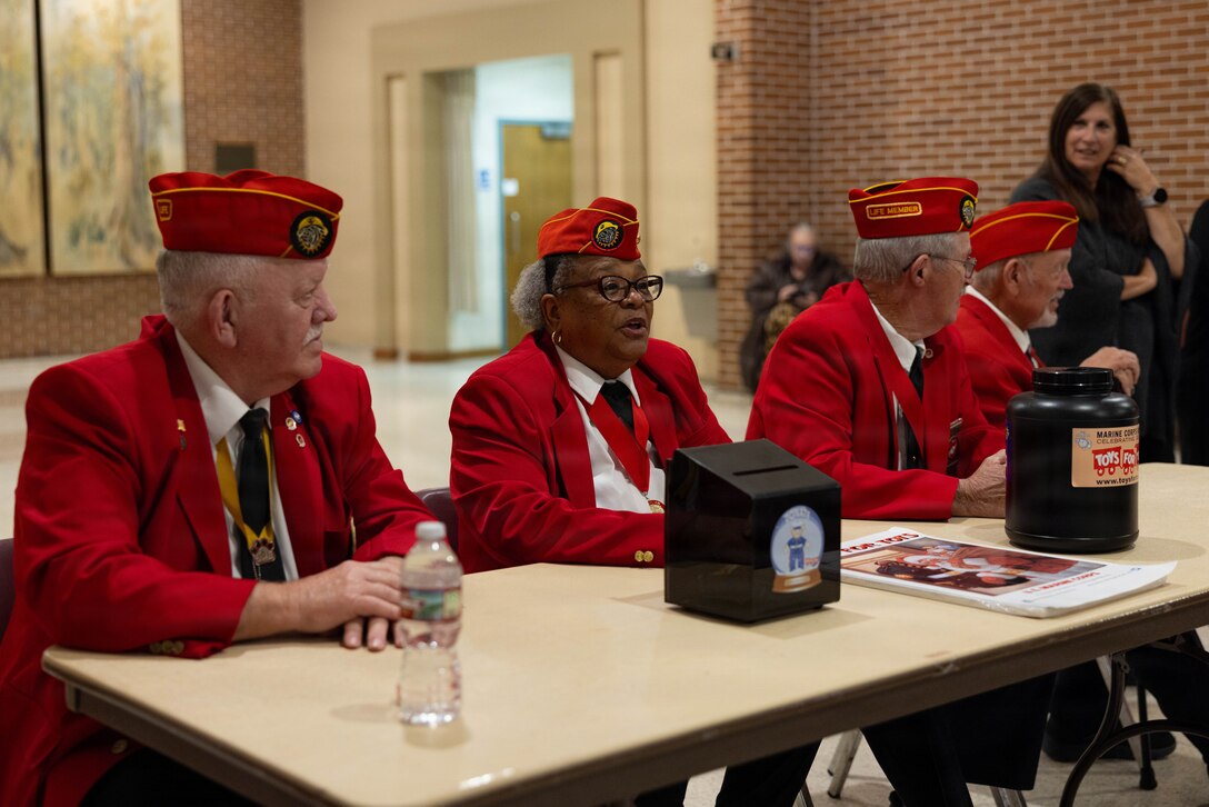 Members of the Marine Corps League collect donations at the Morgan City Municipal Auditorium, Morgan City, Louisiana, Dec. 9, 2025. The Marine Forces Reserve Band performed for the local community to listen to holiday music in the areas surrounding New Orleans while supporting the collecting of new, unwrapped toys for Toys for Tots. (U.S. Marine Corps photo by Lance Cpl. Priscilla Flores)