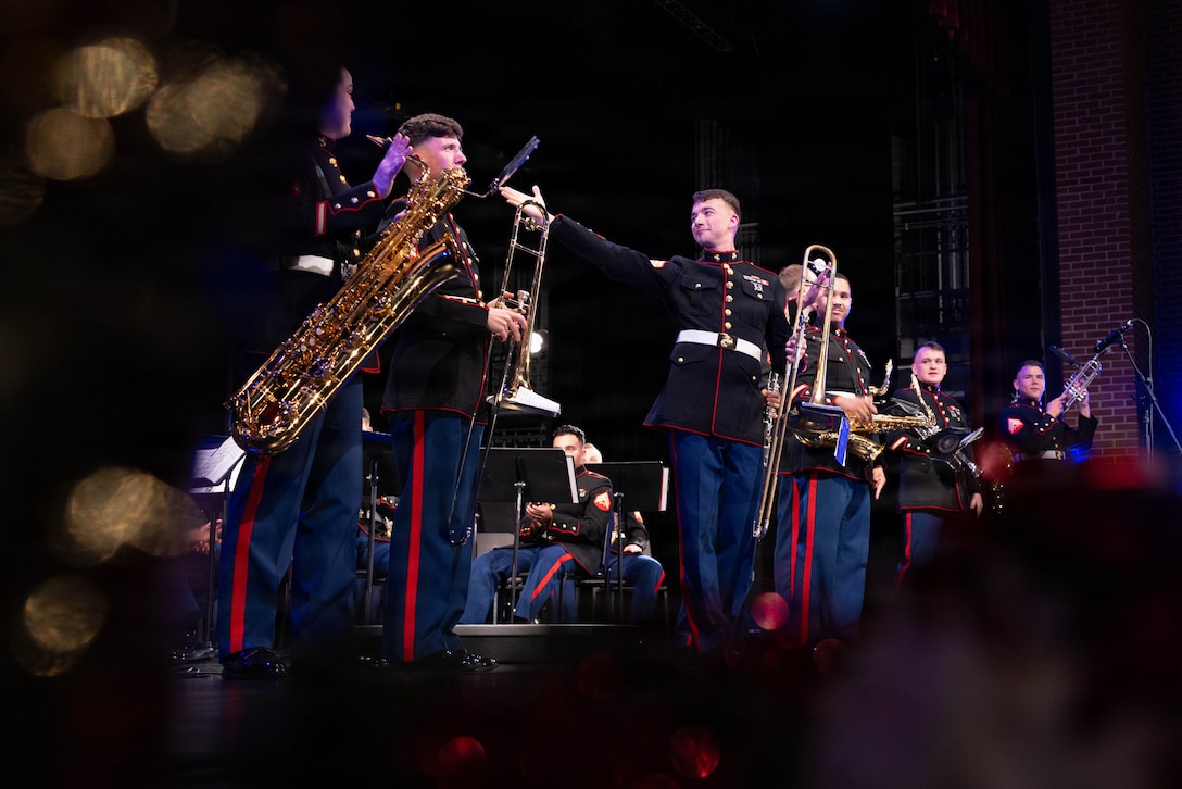 U.S. Marine Corps Sgt. Justin Napier, a trombonist with the Marine Forces Reserve Band, gives praise to his fellow instrumentalists at the Morgan City Municipal Auditorium, Morgan City, Louisiana, Dec. 9, 2025. The Marine Forces Reserve Band performed for the local community to listen to holiday music in the areas surrounding New Orleans while supporting the collecting of new, unwrapped toys for Toys for Tots. (U.S. Marine Corps photo by Lance Cpl. Priscilla Flores)