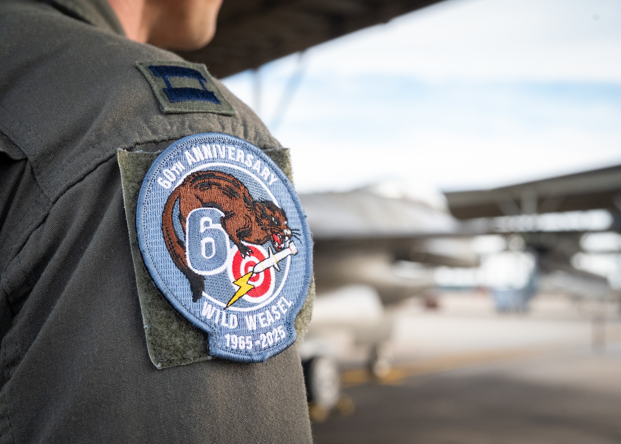 A pilot wears a commemorative patch for a the 60th anniversary of the wild weasels