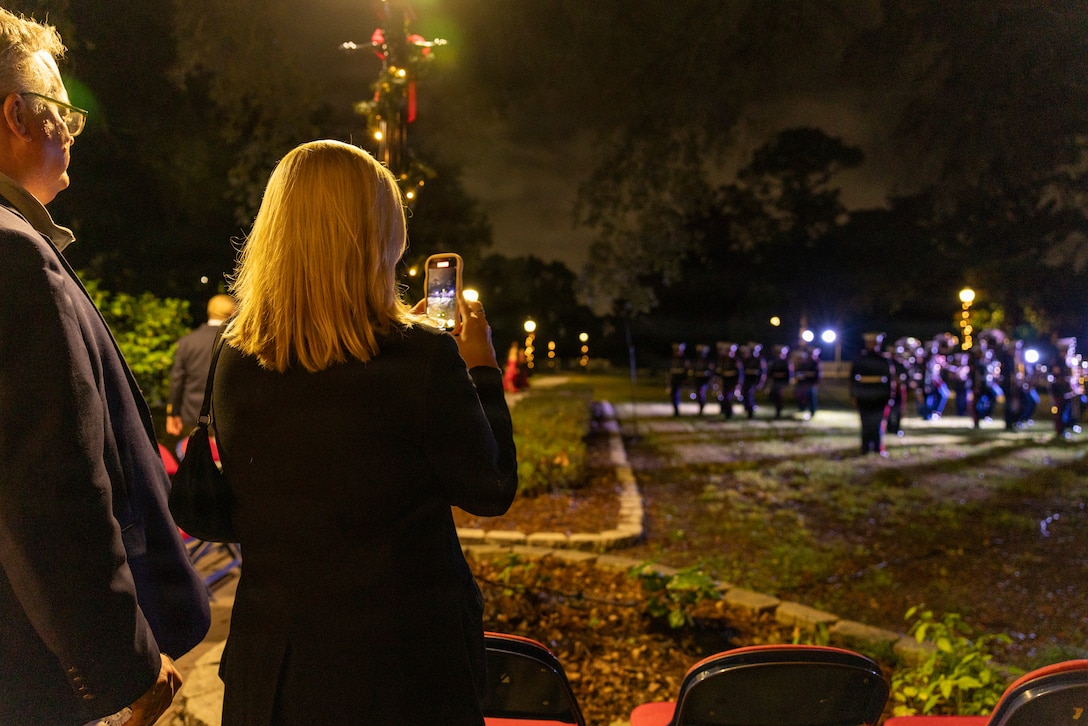 Guests take photos of the Marine Forces Reserve Band performing during the Christmas party hosted by Lt. Gen Leonard F. Anderson IV, commander of Marine Forces Reserve and Marine Forces South, at Quarters A in New Orleans, Dec. 6, 2025. The event supported the Marine Corps Reserve Toys for Tots program, with attendees contributing donations throughout the evening. (U.S. Marine Corps photo by Sgt. Samuel Qin)