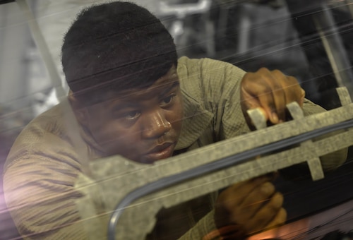 U.S. Airman installs a flexible linear shape charge on an F-35A Lightening II training canopy