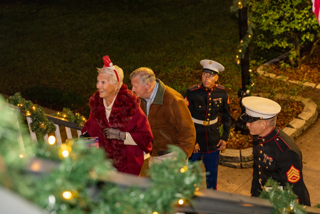 Guests make their way up the stairs during the Christmas party hosted by the Commander of Marine Forces Reserve and Marine Forces South at Quarters A in New Orleans, Dec. 6, 2025. The event supported the Marine Corps Reserve Toys for Tots program, with attendees contributing donations throughout the evening. (U.S. Marine Corps photo by Sgt. Samuel Qin)