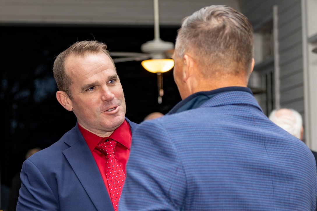 U.S. Marine Corps Lt. Gen. Leonard F. Anderson IV, right, commander of Marine Forces Reserve and Marine Forces South, welcomes U.S. Navy Capt. Andrew M. McGinly, commanding officer of Naval Air Station Joint Reserve Base New Orleans, as he arrives for the annual Christmas party held at Quarters A in New Orleans, Dec. 6, 2025. The event supported the Marine Corps Reserve Toys for Tots program, with guests contributing donations throughout the evening, and featured a concert by the Marine Forces Reserve Band as its main attraction. (U.S. Marine Corps photo by Sgt. Samuel Qin)