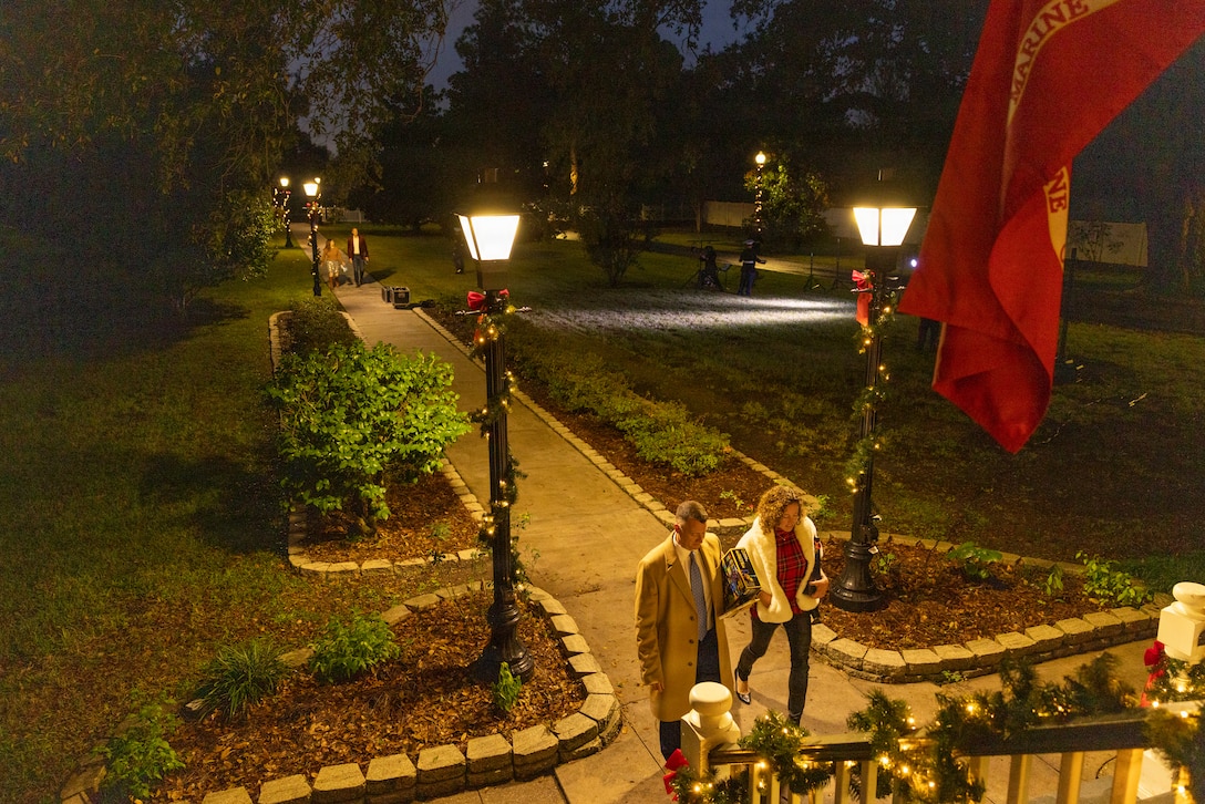 Guests make their way up the stairs during the Christmas party hosted by the Commander of Marine Forces Reserve and Marine Forces South at Quarters A in New Orleans, Dec. 6, 2025. The event supported the Marine Corps Reserve Toys for Tots program, with attendees contributing donations throughout the evening. (U.S. Marine Corps photo by Sgt. Samuel Qin)