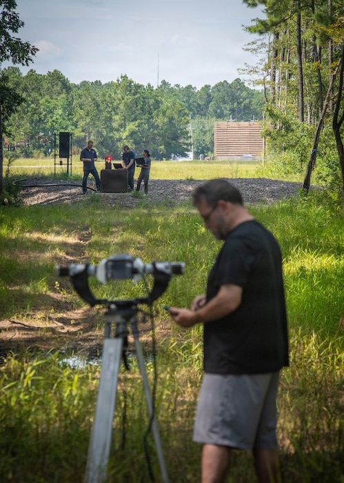 Technician working on electronic equipment at a NIWC Atlantic laser range.
