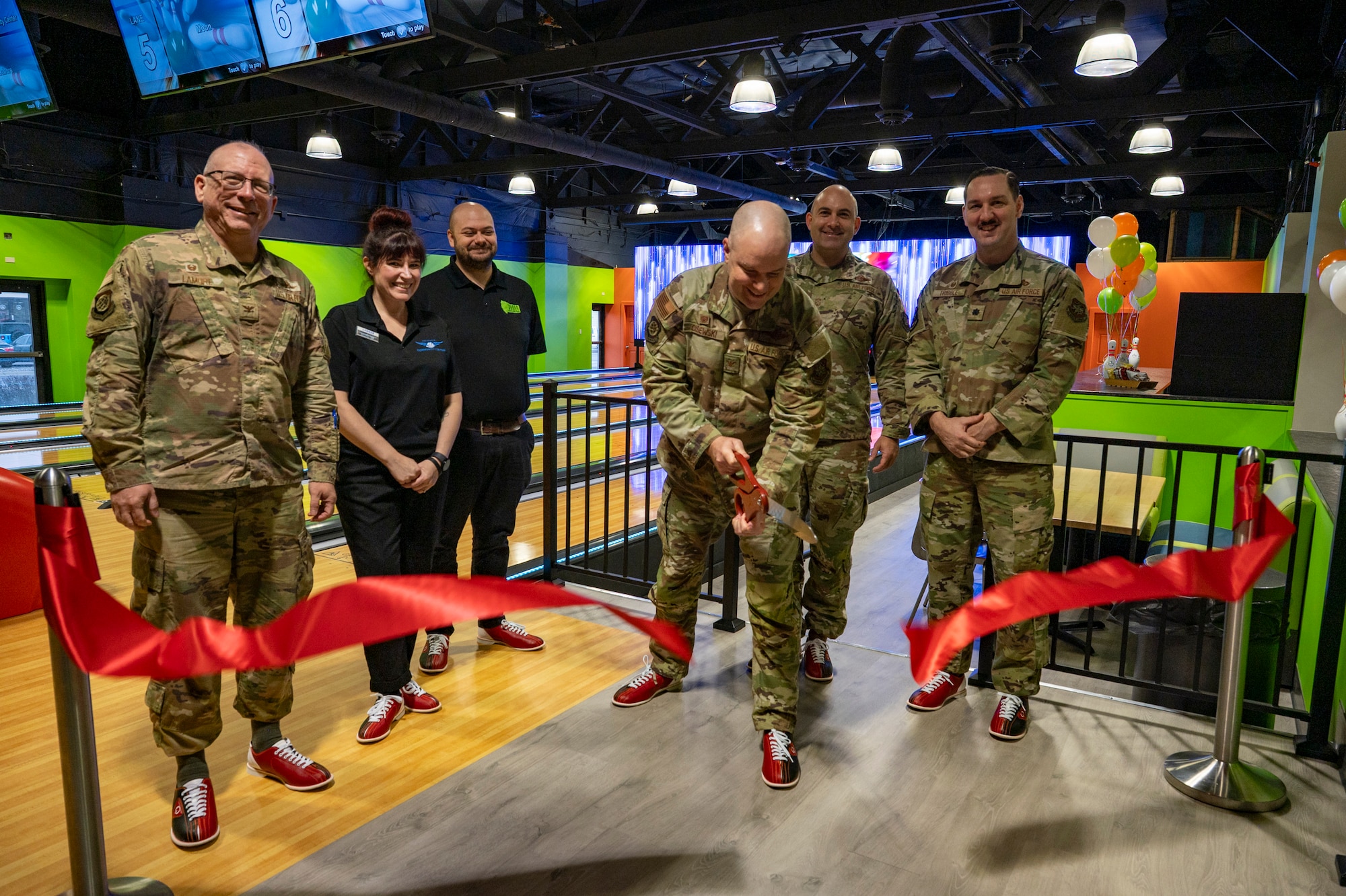 Military members cut a ribbon.