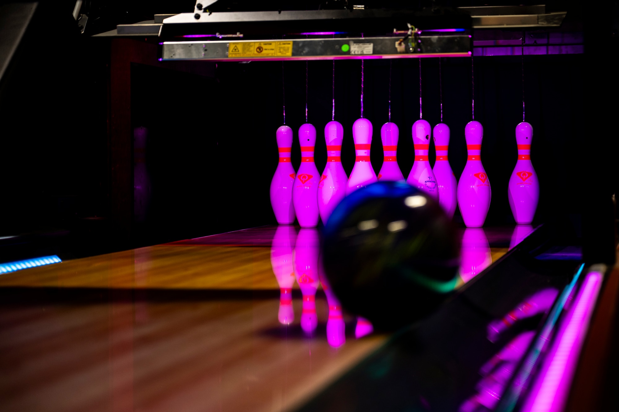 A bowling ball is about to hit bowling pins.