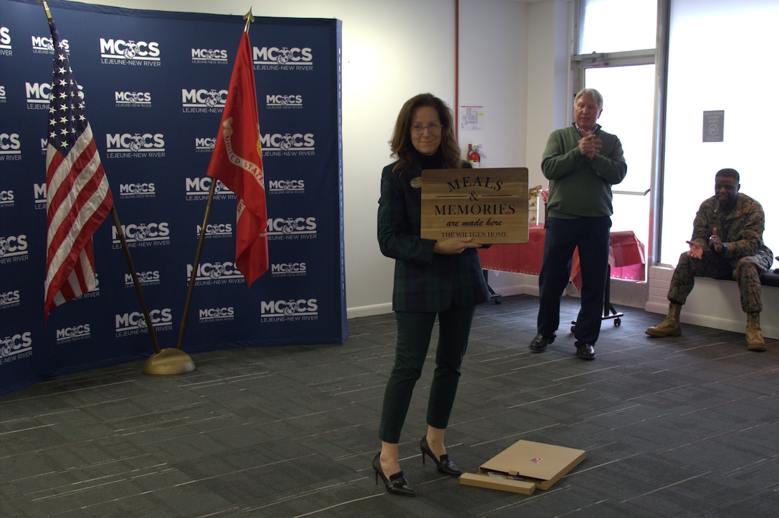 Sarah Wiltgen, assistant chief of staff, Marine Corps Community Services, Marine Corps Installations East, poses with a gift presented to her by the staff on the occasion of her retirement at MCCS headquarters on Marine Corps Base Camp Lejeune, Dec. 12, 2025.