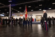 A group of Marines in dress blues present the Marine Corps flag and the American flag inside the Fredericksburg Expo Center