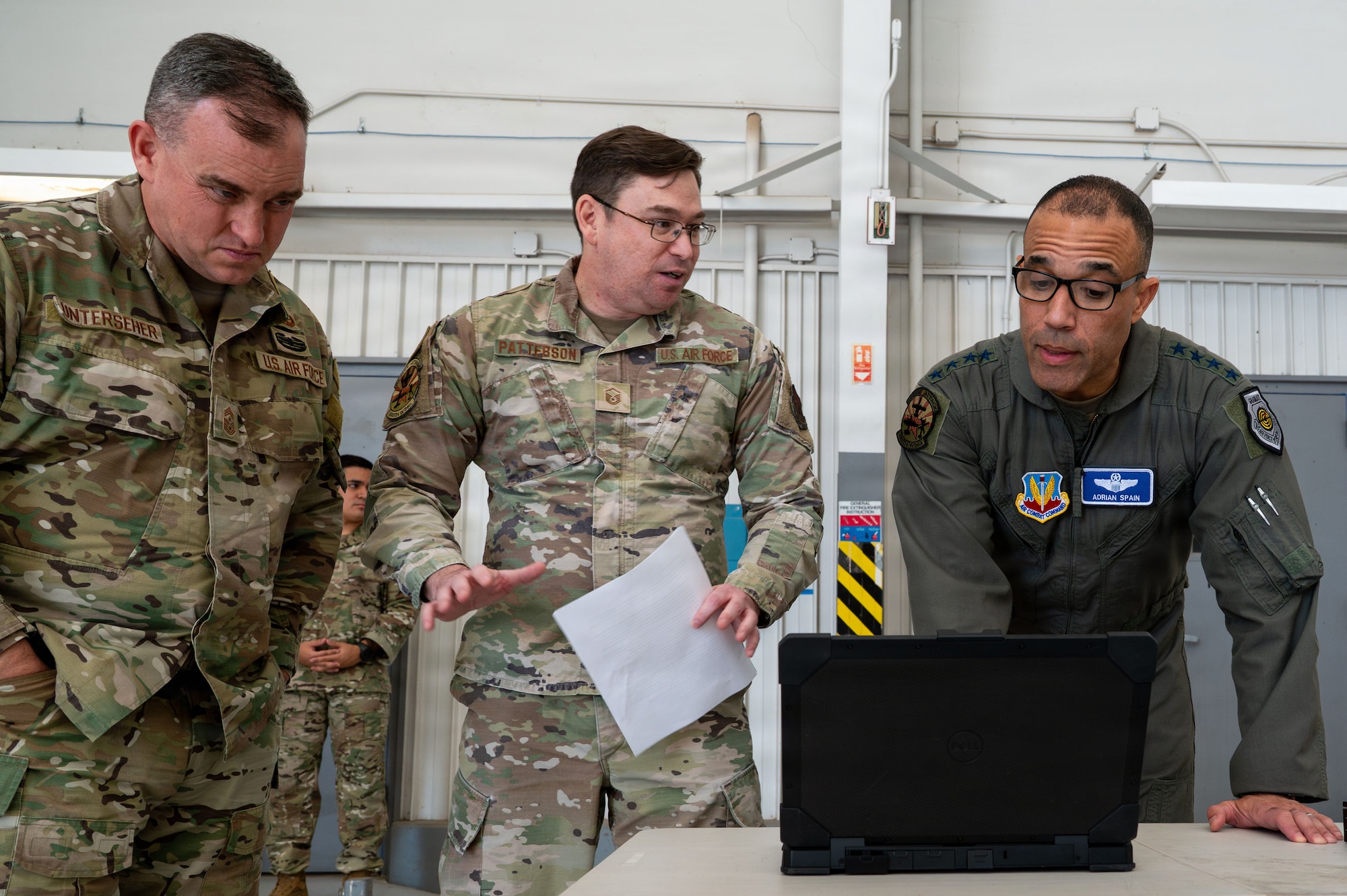 U.S. Air Force Master Sgt. Michael Patterson, 355th Communications Squadron division chief, briefs newly innovated radio capabilities to Gen. Adrian Spain, commander of Air Combat Command, and Chief Master Sergeant Jeremy Unterseher, ACC command chief, at Davis-Monthan Air Force Base, Arizona, Dec. 16, 2025. The ACC command team visited an innovation demonstration where squadrons from across the installation discussed their mission sets and ongoing innovation efforts with Air Combat Command leadership. (U.S. Air Force photo by Senior Airman Jasmyne Bridgers-Matos)