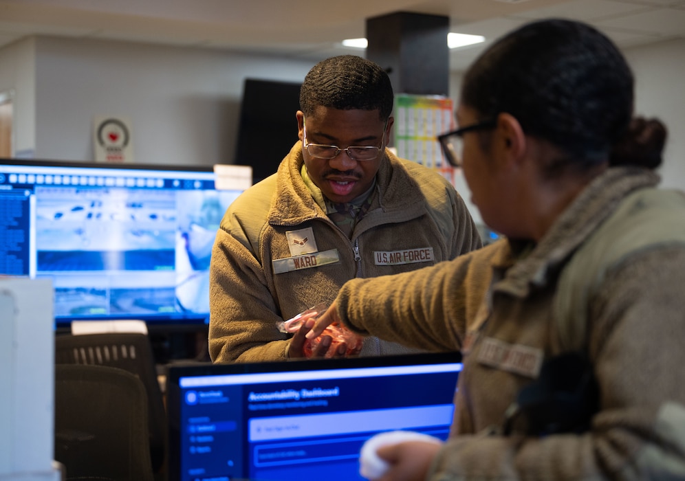 A senior airman passes out candy canes to another airman