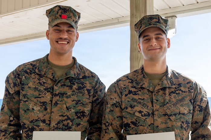 U.S. Marine Corps Cpl. Malikah Warren, 2nd Distribution Support Battalion, 2nd Marine Logistics Group, left, and Cpl. Zbigniew Adamczyk, Marine Medium Tiltrotor Training Squadron 204, Marine Aircraft Group 26, 2nd Marine Aircraft Wing, right, pose for a photo after receiving Red Cross Lifesaving Awards at Marine Corps Base Camp Lejeune, North Carolina, Dec. 16, 2025. The Marines received the Lifesaving Award, the second highest award the American Red Cross bestows, for rescuing people during an emergency at a local beach earlier this year. (U.S. Marine Corps photo by Lance Cpl. Erica S. Padgett)