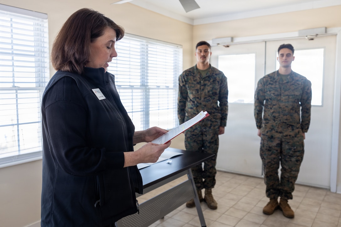 Lauren Bolen, interim director of the American Red Cross, presents Cpl. Malikah Warren, 2nd Distribution Support Battalion, 2nd Marine Logistics Group, left, and Cpl. Zbigniew Adamczyk, Marine Medium Tiltrotor Training Squadron 204, Marine Aircraft Group 26, 2nd Marine Aircraft Wing, right, with Red Cross Lifesaving Awards at Marine Corps Base Camp Lejeune, North Carolina, Dec. 16, 2025. The Marines received the Lifesaving Award, the second highest award the American Red Cross bestows, for rescuing people during an emergency at a local beach earlier this year. (U.S. Marine Corps photo by Lance Cpl. Erica S. Padgett)