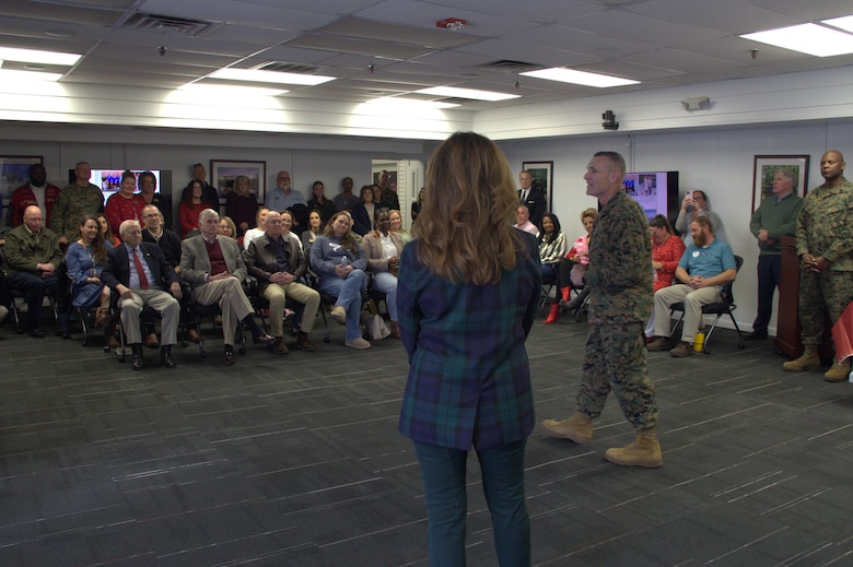 Sarah Wiltgen, assistant chief of staff, Marine Corps Community Services, Marine Corps Installations East, listens as Brig. Gen. Ralph J. Rizzo, Jr., commanding general, MCIEAST – Marine Corps Base (MCB) Camp Lejeune recaps highlights of her career during her retirement ceremony held at MCCS headquarters on MCB Camp Lejeune, Dec. 12, 2025.