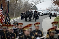 The U.S. Army Band is in the foreground with an Army caisson approaching on the road in the background.
