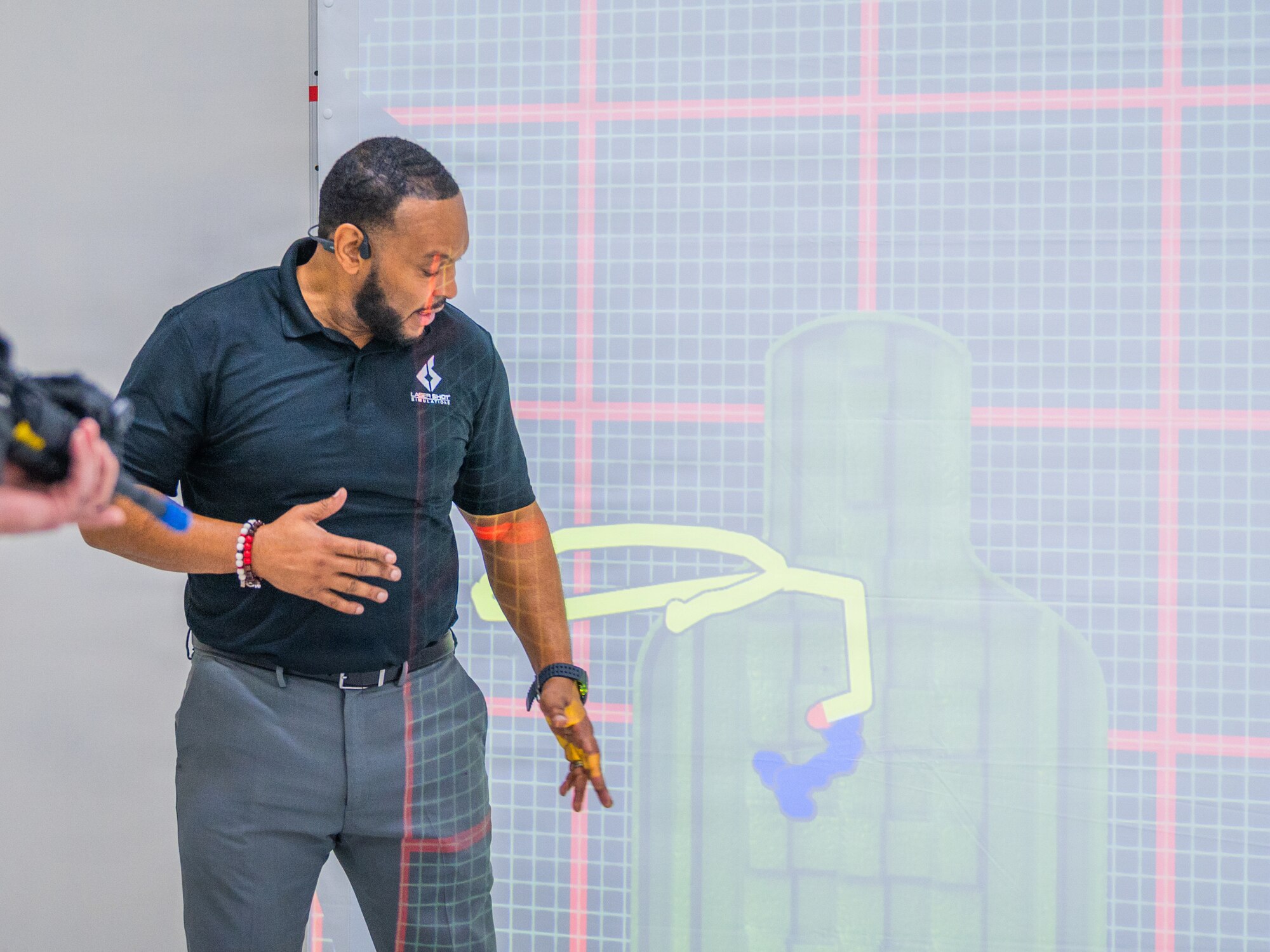 Michael Clark, LaserShot Simulations representative, provides insight into the feedback system of a virtual range simulator during a demonstration, Dec. 15, 2025, at Luke Air Force Base, Arizona.
