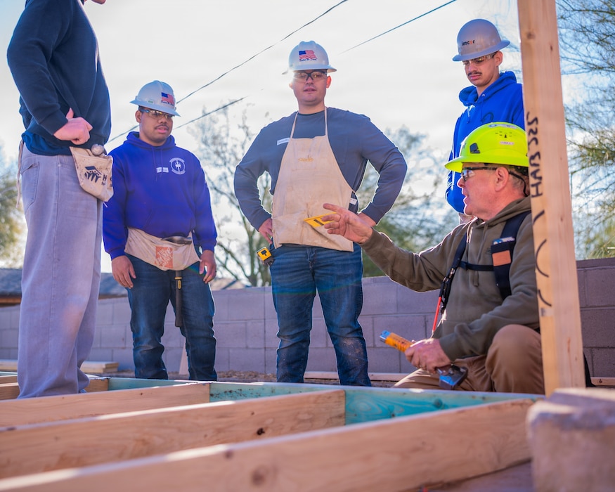 A Habitat for Humanity team member instructs Airmen from the 607th Air Control Squadron on construction practices during a Habitat for Humanity volunteer event, Dec. 13, 2025, at Buckeye, Arizona.
