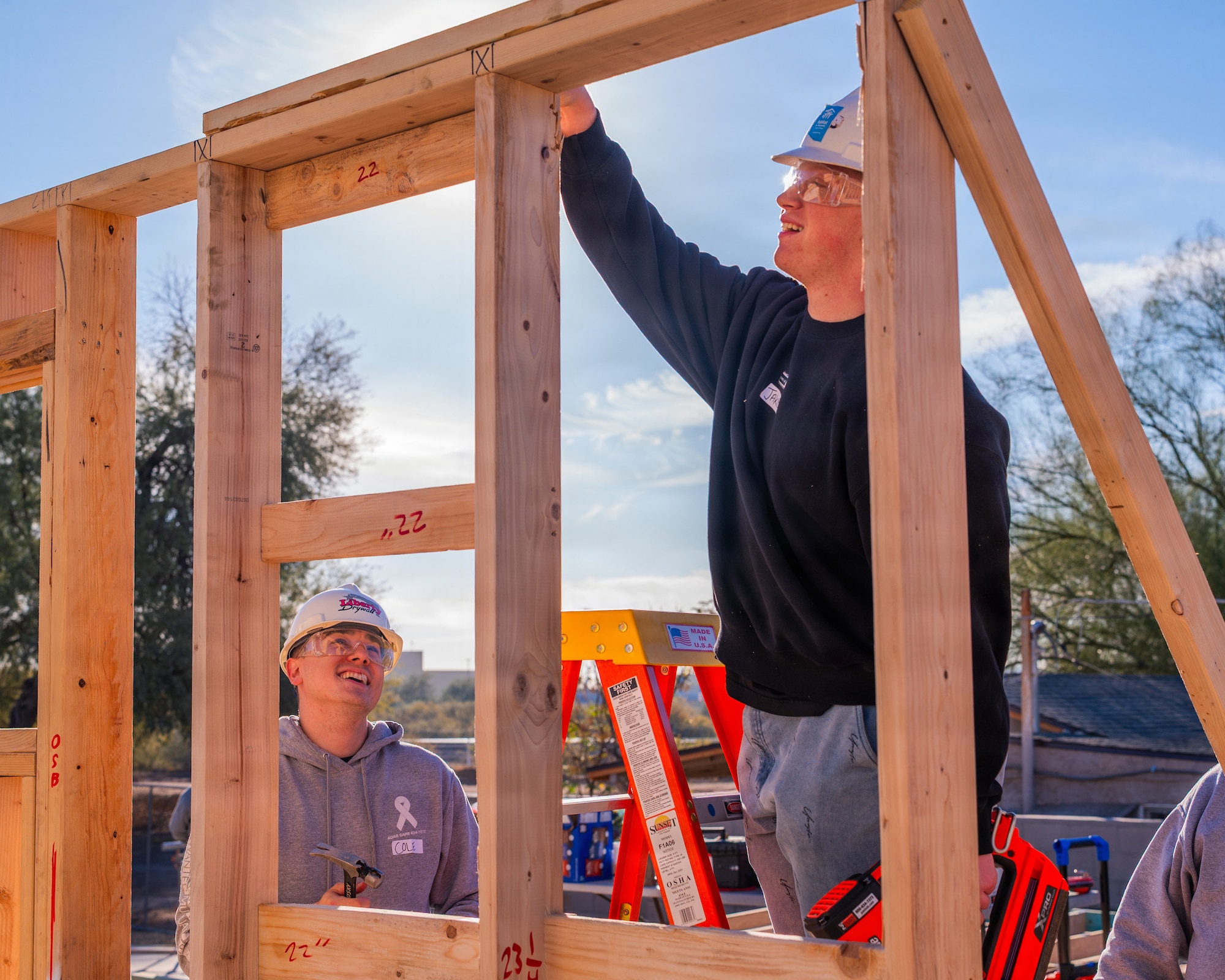 U.S. Air Force Staff Sgt Cole Failla (left), 607th Air Control Squadron cyber systems non-commisioned officer in charge, and Airman 1st Class Jakob Schofield (right), 607th Air Control Squadron cyber systems technician, construct a wall during a Habitat for Humanity volunteer event, Dec. 13, 2025, at Buckeye, Arizona.