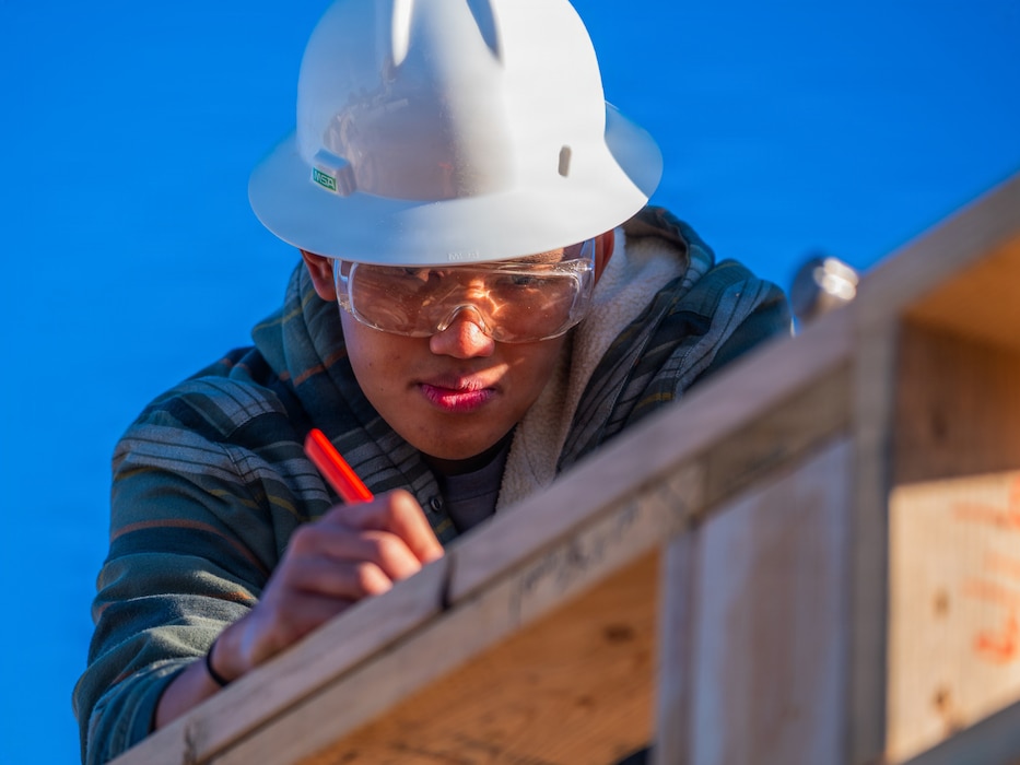 U.S. Air Force Airman 1st Class Louie Magcalas, 607th Air Control Squadron cyber systems technician, marks a measurement on a beam during a Habitat for Humanity volunteer event, Dec. 13, 2025, at Buckeye, Arizona.