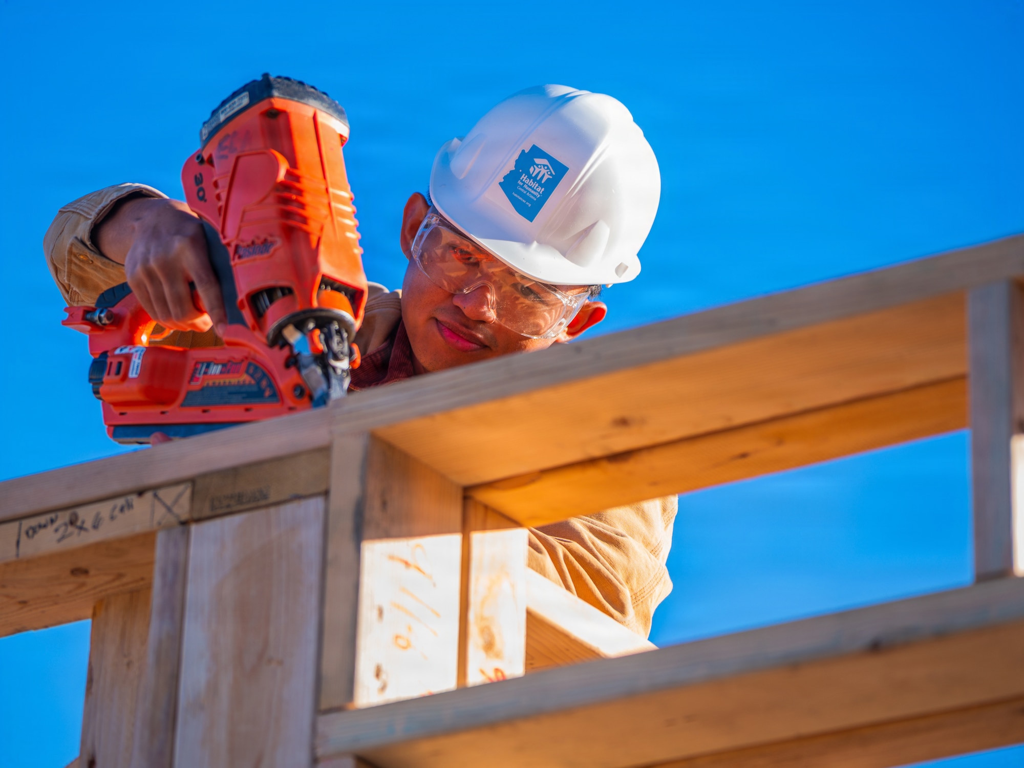 U.S. Air Force Airman 1st Class Andre Castro, 607th Air Control Squadron cyber systems technician, utilizes a nail gun to construct a wall during a Habitat for Humanity volunteer event, Dec. 13, 2025, at Buckeye, Arizona.