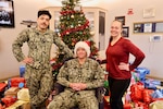 TWENTYNINE PALMS, Calif. (Dec. 17, 2025) — Navy Chaplain Lt. Cmdr. Nicholas Suddath (center), Religious Program Specialist 3rd Class Diego Escalante (left) and Command Ombudsman Jennifer Belding (right) pose in front of donated gifts during the Angel Tree program at Naval Hospital Twentynine Palms. The community-driven initiative provided more than 250 holiday gifts to 83 military children this year, anonymously connecting volunteers with Sailors’ families in need and helping make the holiday season brighter across the command. (U.S. Navy photo by Christopher Jones/NMRTC Twentynine Palms Public Affairs Officer)