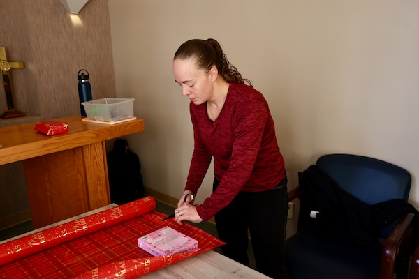 TWENTYNINE PALMS, Calif. (Dec. 17, 2025) — Command Ombudsman Jennifer Belding wraps holiday gifts during the Angel Tree program at Naval Hospital Twentynine Palms. The community-driven initiative, coordinated by the hospital’s chaplain team, anonymously connects volunteers with military children in need to help make the holiday season brighter for Sailors’ families. (U.S. Navy photo by Christopher Jones/NMRTC Twentynine Palms Public Affairs Officer)