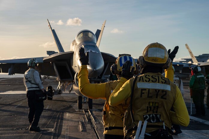 U.S. Navy Sailors direct an F/A-18F Super Hornet, attached to Strike Fighter Squadron (VFA) 41, on the flight deck of Nimitz-class aircraft carrier USS Abraham Lincoln (CVN 72) in the Philippine Sea, Dec. 19, 2025. The Abraham Lincoln Carrier Strike Group is underway conducting routine operations in the U.S. 7th Fleet area of operations. Units assigned to U.S. 7th Fleet conduct regular Indo-Pacific patrols to deter aggression, strengthen alliances and partnerships, and advance peace through strength. (U.S. Navy photo by Mass Communication Specialist 3rd Class Nathaly Cruz)