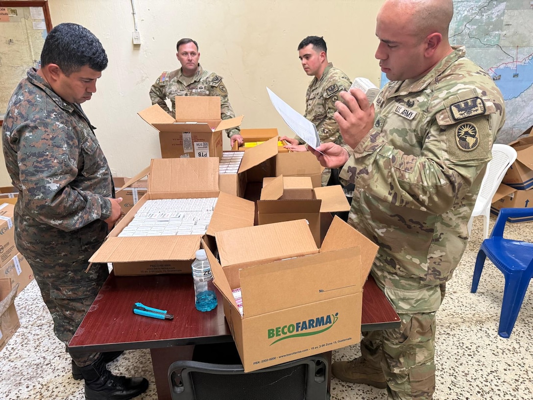 People in military uniforms sort through medical supplies