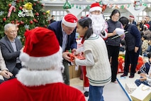 Lt. Gen. Joseph Hilbert, Eighth Army commanding general, hands a young girl a Christmas present at Namsan-won Orphanage in Seoul, South Korea, Dec. 19, 2025.