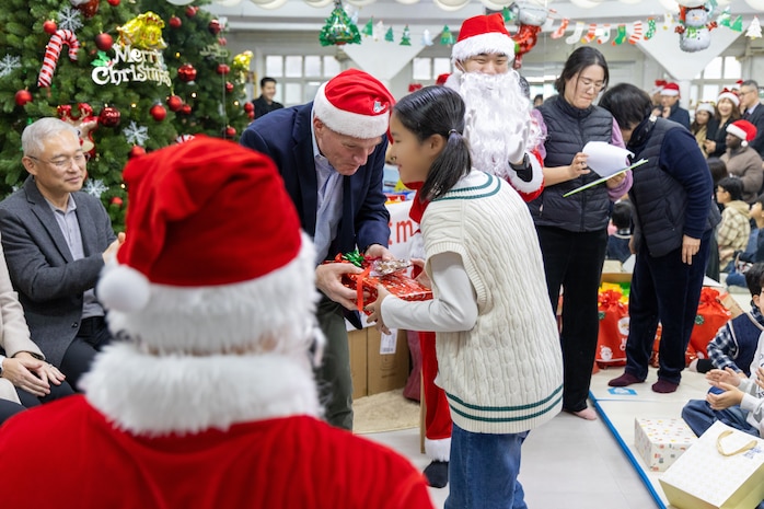 Lt. Gen. Joseph Hilbert, Eighth Army commanding general, hands a young girl a Christmas present at Namsan-won Orphanage in Seoul, South Korea, Dec. 19, 2025.