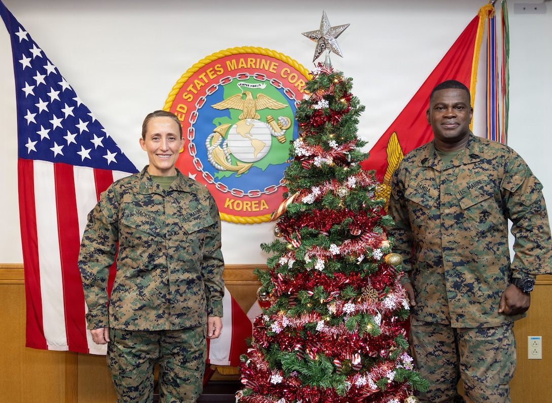 U.S. Marine Corps Maj. Gen. Valerie A. Jackson, commander of U.S. Marine Corps Forces, Korea, and Ismael G. Bamba, command senior enlisted leader of MARFORK, pose for a photo to wish all Marines, Sailor, Soldier, civilians and family members with MARFORK a happy holidays, on USAG Camp Humphreys, South Korea, Dec. 23, 2025. MARFORK is the U.S. Marine Corps' service component for United States Forces Korea (USFK) and United Nations Command (UNC). It commands all U.S. Marine forces assigned to USFK and UNC; advises USFK and UNC on the capabilities, support, and proper employment of Marine forces in defense of the Republic of Korea (ROK); and serves as the U.S. Marine Corps’ representative to the Commandant of the ROK Marine Corps.