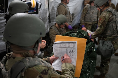 Medical technicians assess a patient.