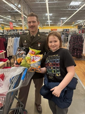 Soldier posing with a kid.