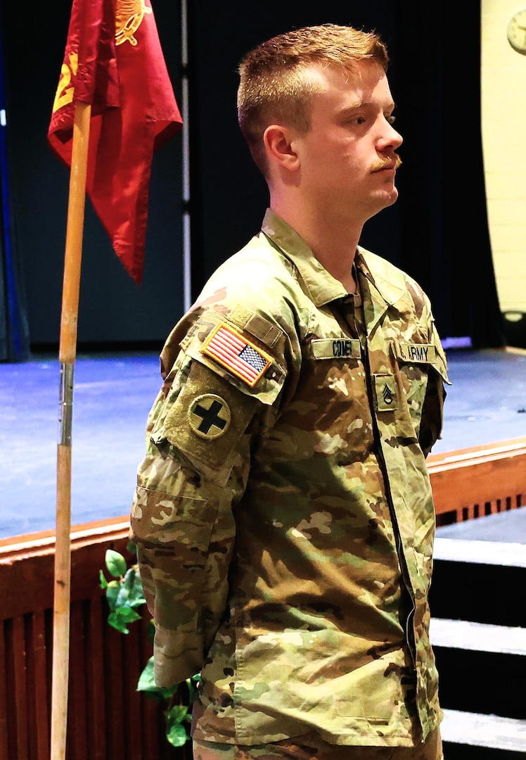 Illinois Army National Guard Staff Sgt. Bryce Comer of the 725th Transportation Company stands in front of his unit after receiving Command Sgt. Maj. Kehinde Salami’s coin.