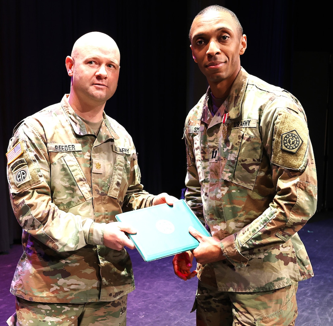 Maj. (promotable) Benjamin Reeder, Commander of the 198th Combat Sustainment Support Battalion, presents 725th Transportation Company Commander Capt. (promotable) Charles Smith with a Meritorious Service Medal during the unit’s Welcome Home Ceremony.