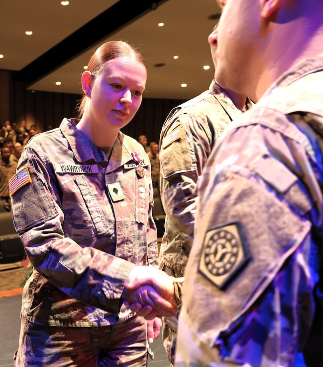 Maj. (promotable) Benjamin Reeder, Commander of the 198th Combat Sustainment Support Battalion, presents 725th Transportation Company Spc. Emilia Wawryniuk with a Meritorious Service Medal.