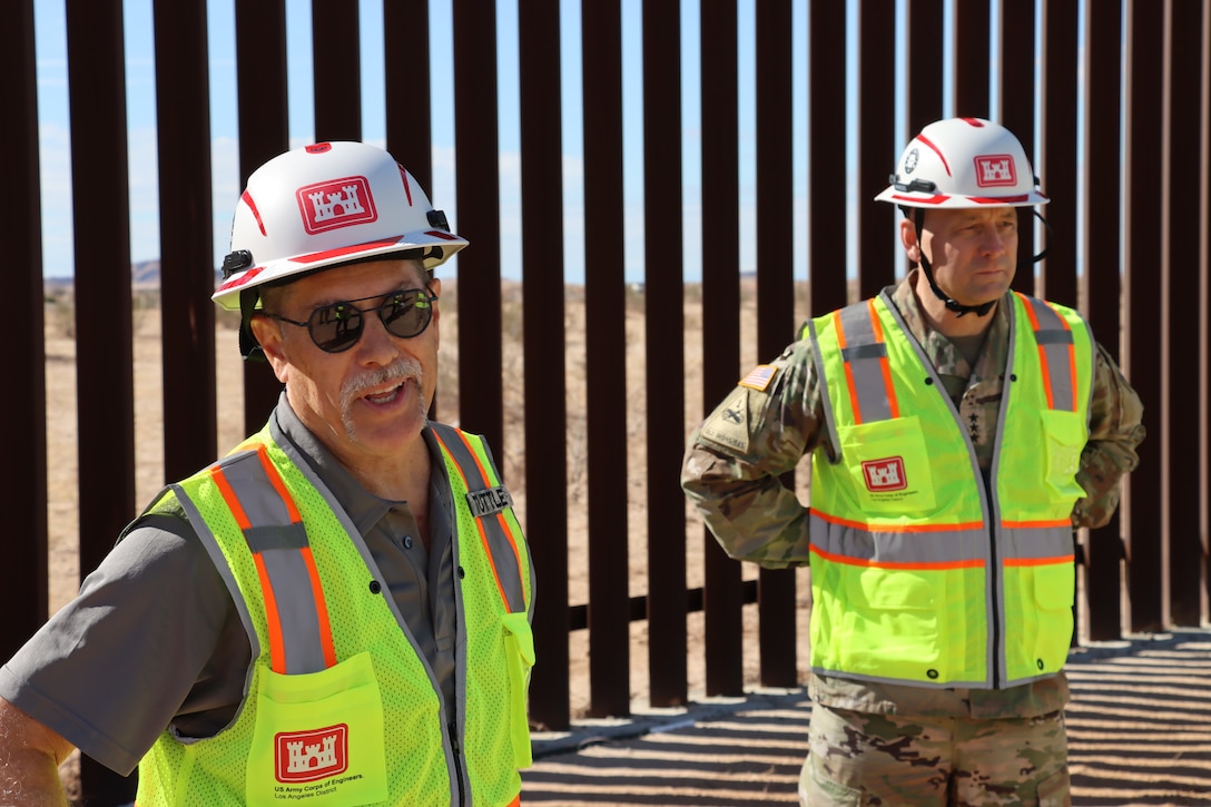 Mike Tuttle, a project manager assigned to the South Pacific Border Task Force, left, beside U.S. Army Corps of Engineers Commander Lt. Gen. William Graham, details panel installation progress at the BMGR-1 project site Nov. 17 near Yuma, Arizona. USACE is replacing permanent border barriers along the southern border of the U.S. at the direction of the U.S. Army by the Secretary of War, in response to the presidential national emergency declaration dated Jan. 20, 2025, authorizing the use of Section 2803 of Title 10, U.S. Code.