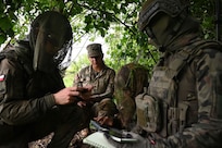 U.S. Army Sgt. Joseline Sosa, a forward observer with 1st Battalion, 178th Infantry Regiment, Illinois Army National Guard, relays information to her Polish Territorial Defence Force counterparts during remote observer training in Toruń, Poland, June 6, 2025.