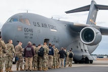 A photo of people standing in front of a C-17 Globemaster III.