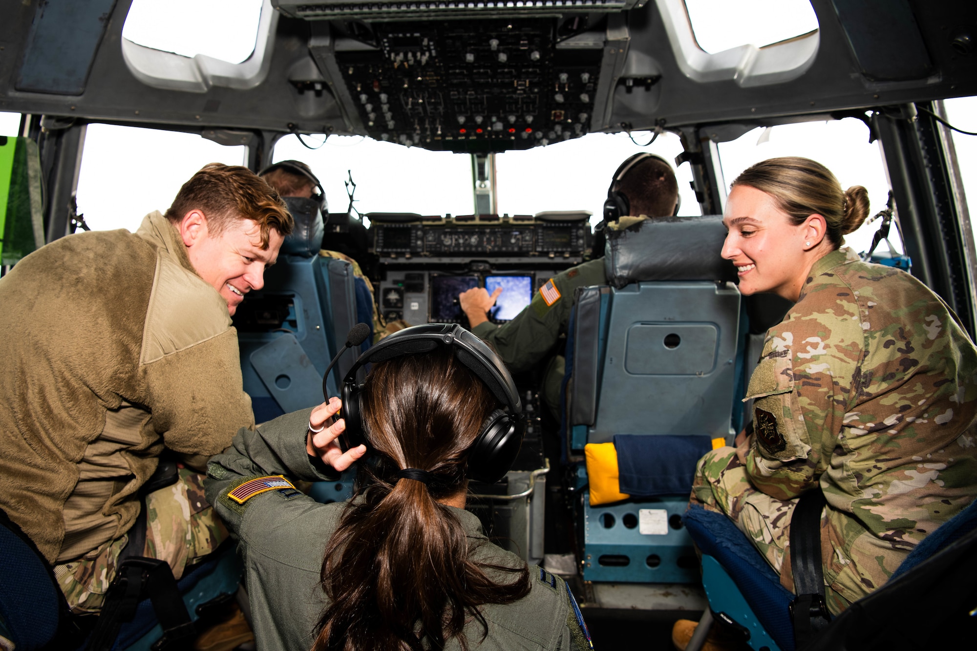 A photo of people conversing in the cockpit of a C-17 Globemaster III.