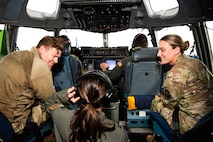 A photo of people conversing in the cockpit of a C-17 Globemaster III.