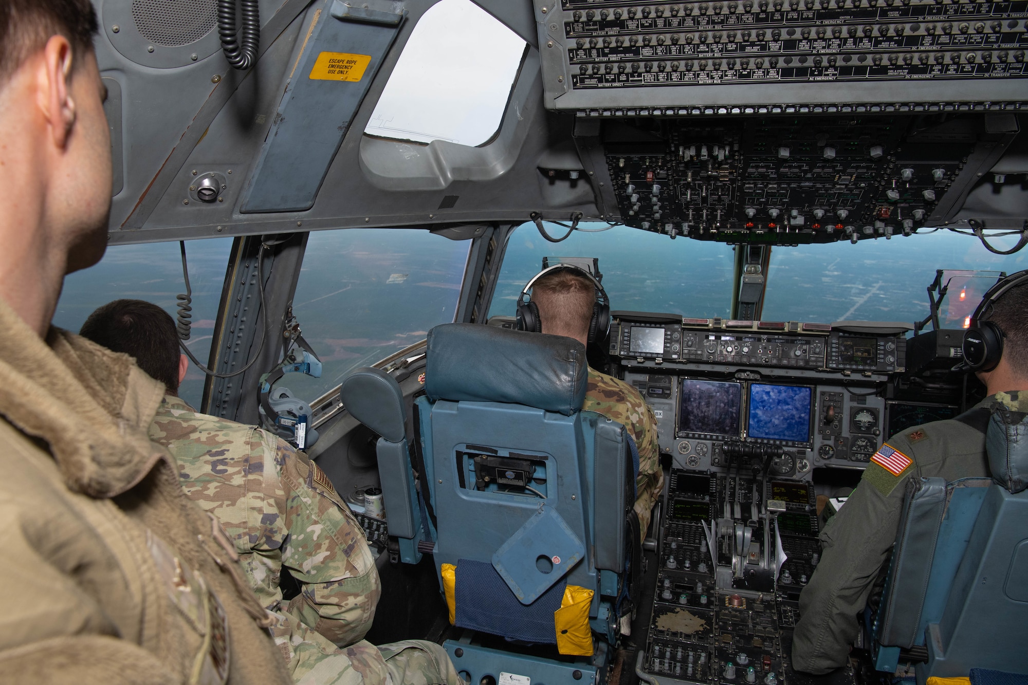 A photo of service members looking out the window of a C-17 Globemaster III.