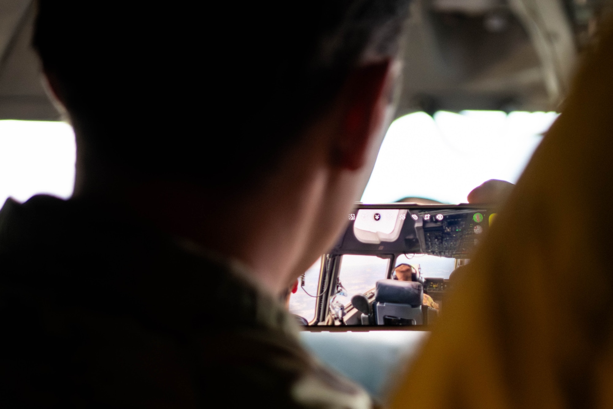 A photo of a person taking a picture in the cockpit of a C-17 Globemaster III