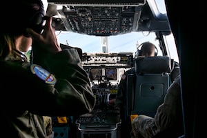 A photo of people conversing in the cockpit of a C-17 Globemaster III.