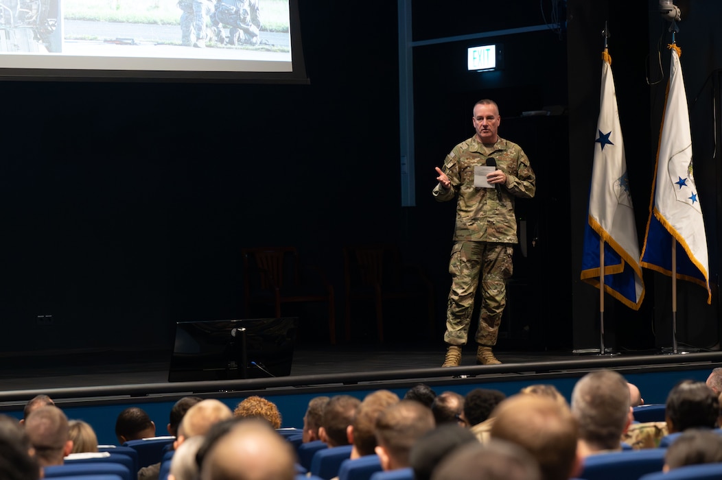 U.S. Chief Master Sgt. of the Air Force David Wolfe speaks to Airmen at an all-call during a visit at Ramstein Air Base, Germany, Dec. 23, 2025. Wolfe emphasized that the service draws its strength from Airmen and their families, aligning with shared host installation, headquarters, and tenant unit  priorities. (U.S. Air Force photo by Airman 1st Class Rebecca Harima)