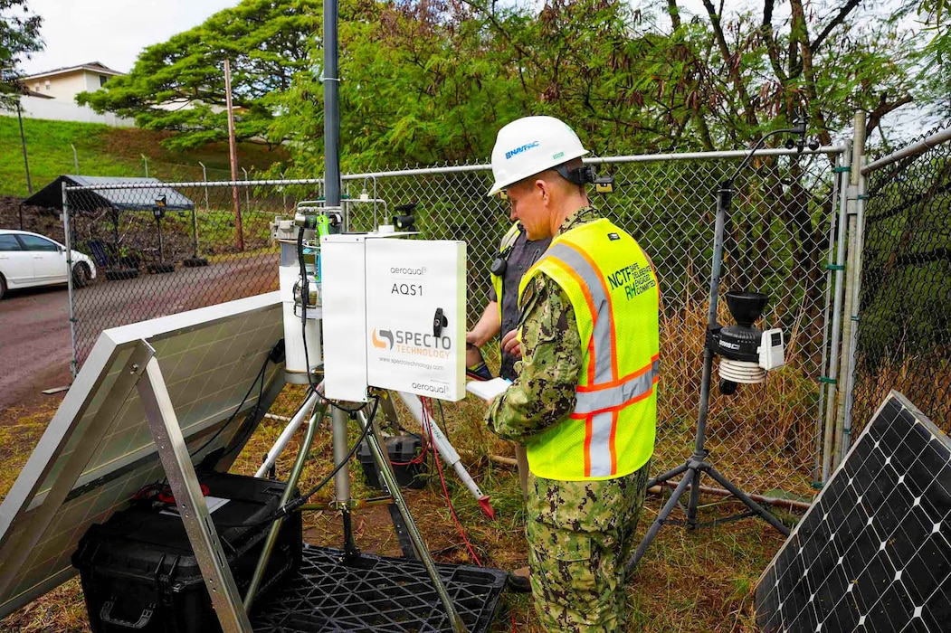 Cmdr. Benjamin Dunn, deputy director for environment and remediation, Navy Closure Task Force–Red Hill (NCTF-RH), inspects an air quality monitoring station at the Red Hill Bulk Fuel Storage Facility (RHBFSF) in Honolulu, Dec. 11, 2025. In accordance with requirements set forth by the Hawaii Department of Health,  NCTF-RH installed the AQM network in and around the RHBFSF to continuously monitor air quality, measure potential volatile organic compounds, collect atmospheric data, and ensure a safe environment throughout the tank cleaning process. NCTF-RH was established by the Department of the Navy to safely decommission the RHBFSF and emphasize the Navy's commitment to the community and the environment. NCTF-RH continues to engage with the people of Hawaii, regulatory agencies, and other stakeholders as it safely and deliberately decommissions the facility. (U.S. Navy photo by Mass Communication Specialist 3rd Class Krystal Diaz)