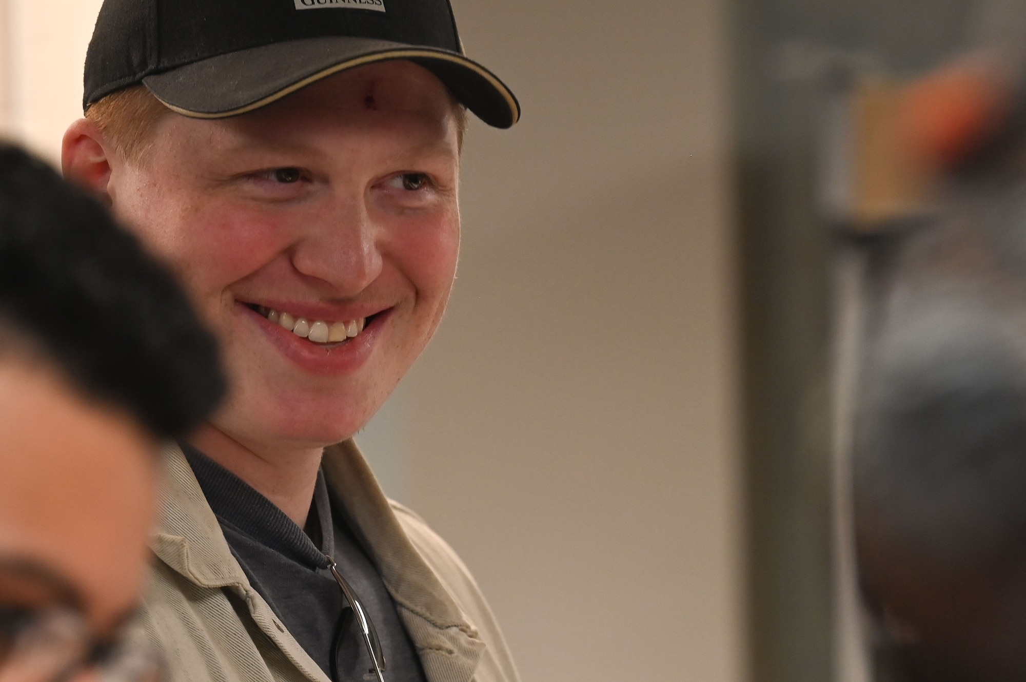 U.S. Air Force Senior Airman Lewis Tobin, 355th Civil Engineer Squadron Explosive electrical and environmental systems journeyman smiles as his Thanksgiving meal is prepared at Davis-Monthan Air Force Base, Arizona, Nov. 27, 2025. The Desert Inn Dining Facility prepares a traditional Thanksgiving meal each year for Airmen stationed away from family, filling the gap of a home cooked meal prepared and served with honor and respect for their service and sacrifice. (U.S. Air Force photo by Staff Sgt. Kahdija Slaughter)