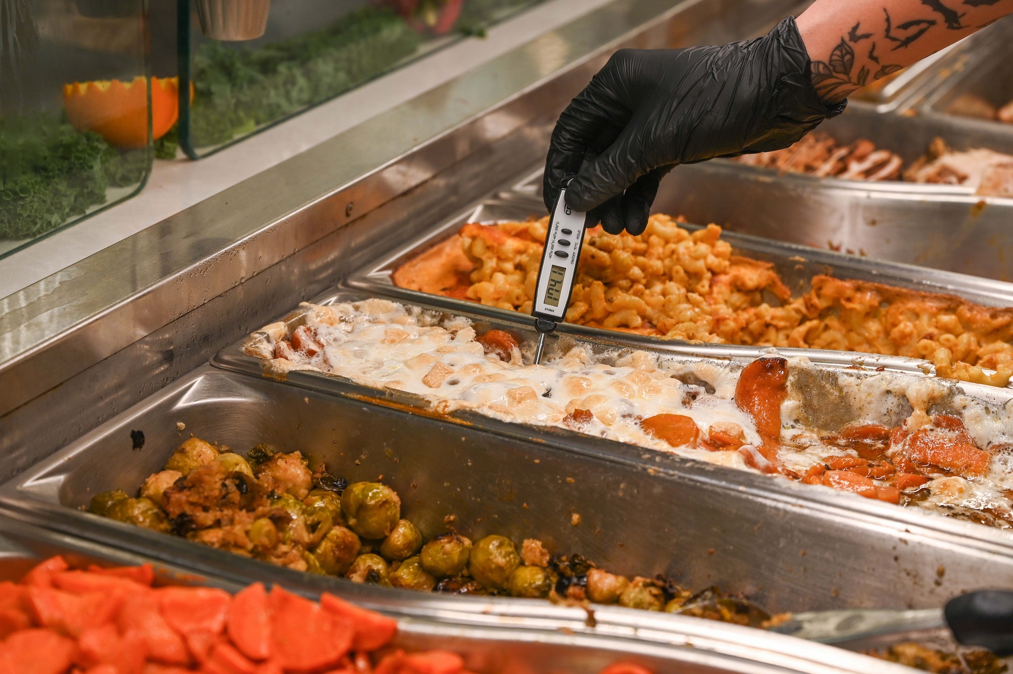 U.S. Air Force Senior Airman Alexander Mullis, 355th Force Support Squadron food service apprentice, conducts temperature checks for the Thanksgiving meal at Davis-Monthan Air Force Base, Arizona, Nov. 27, 2025. Base leaders dedicated time to help serve the Thanksgiving meal to DM service members, showing appreciation for their impact to the mission. (U.S. Air Force photo by Staff Sgt. Kahdija Slaughter)