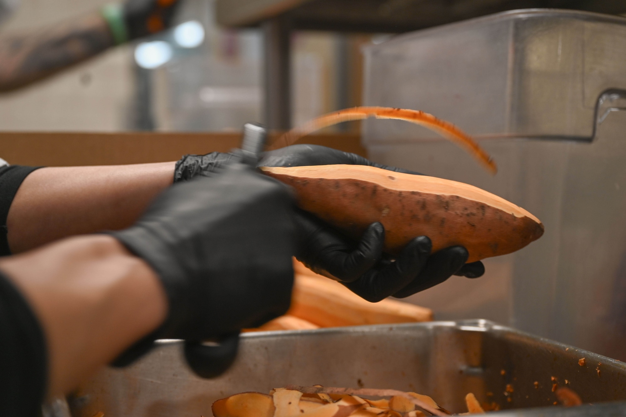 Gergana Tomei, an Aramark chef working with the 355th Force Support Squadron Desert Inn Dining Facility, peels sweet potatoes for the Thanksgiving day meal at Davis-Monthan Air Force Base, Arizona, Nov. 27, 2025. The DFAC team prepared Thanksgiving meal options including roast turkey and gravy, baked ham with glaze, sweet potato casserole, mashed potatoes, and an assortment of other side dishes. Base leaders dedicated time to help serve the Thanksgiving meal to DM service members, showing appreciation for their impact to the mission. (U.S. Air Force photo by Staff Sgt. Kahdija Slaughter)